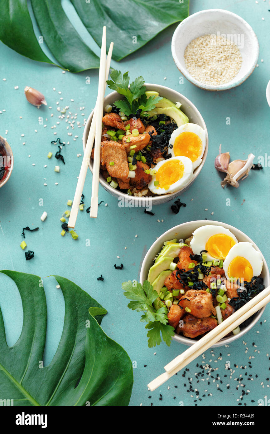 Top view poke bowls of fried rice, chicken fillet and eggs top view. Asian food concept Stock Photo