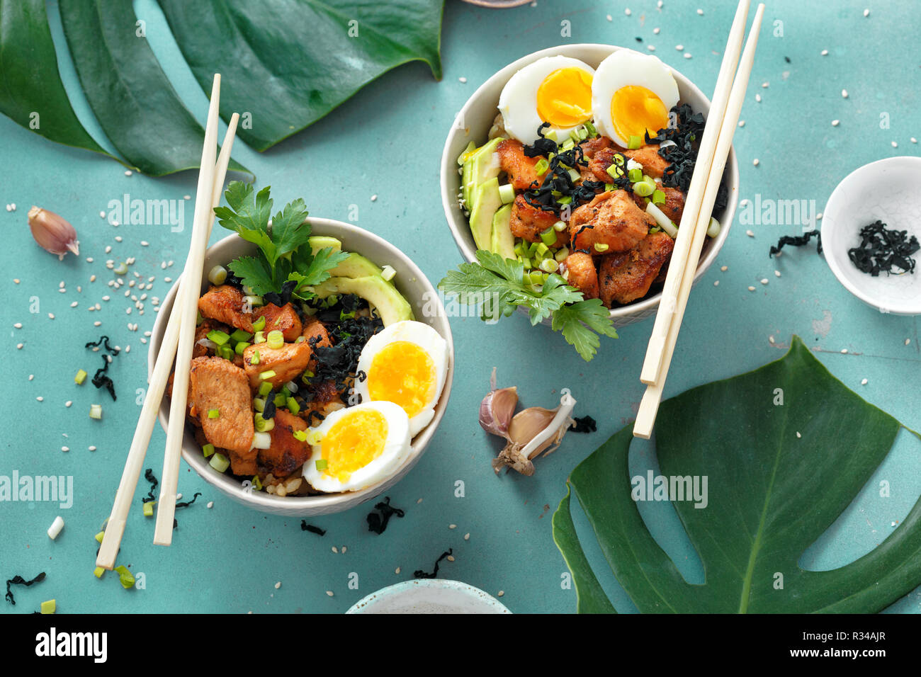 Two poke bowl of fried rice, chicken fillet and eggs top view. Asian food concept Stock Photo