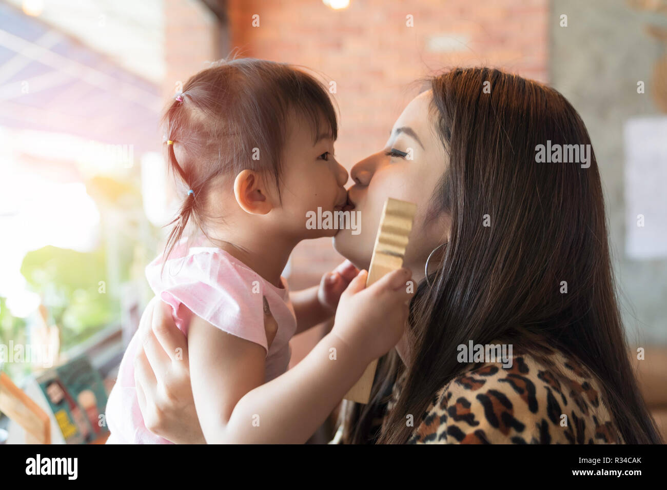 Asian family happiness, with baby girl and parent in the cafe. Stock Photo