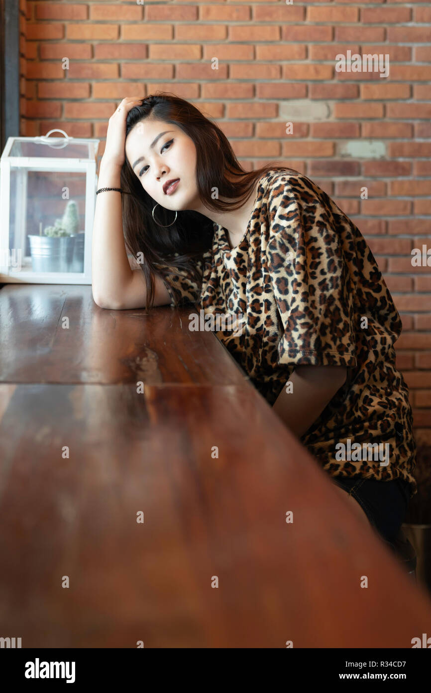 A beautiful woman portrait. Asian teenager concept, with tiger line shirt in the vintage cafe. Stock Photo