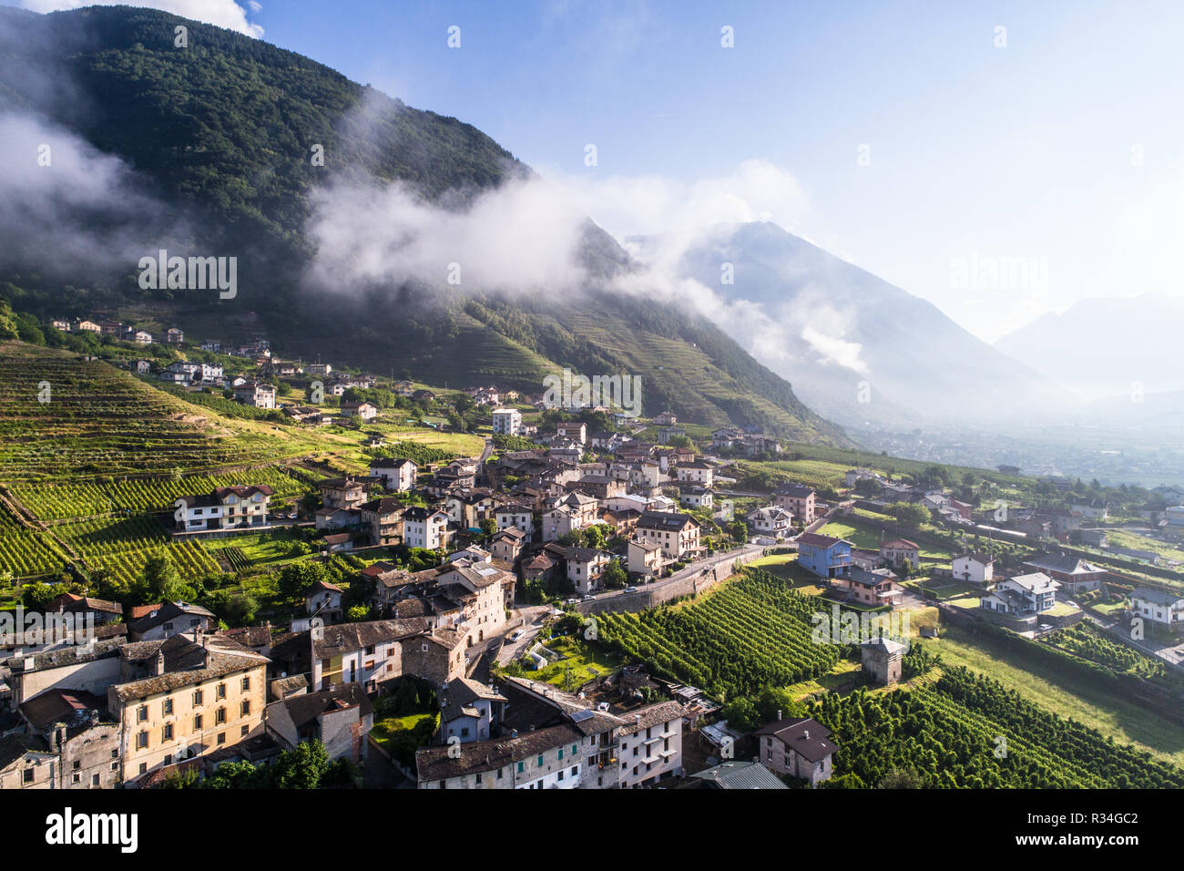 Little village in Valtellina, houses and vineyards, panoramic view from a drone. Italian Alps - Tirano Stock Photo
