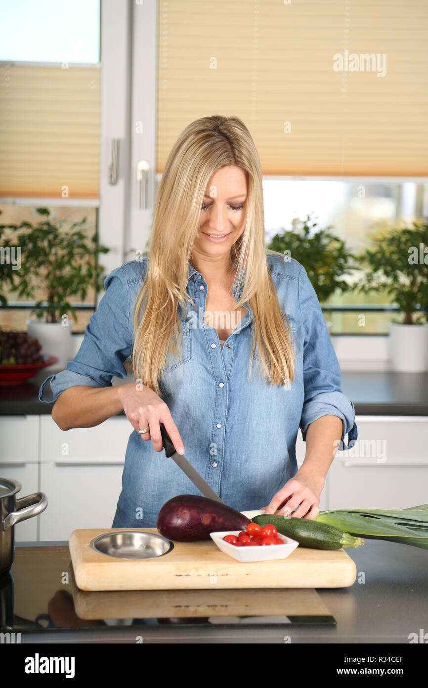 woman cuts vegetables Stock Photo