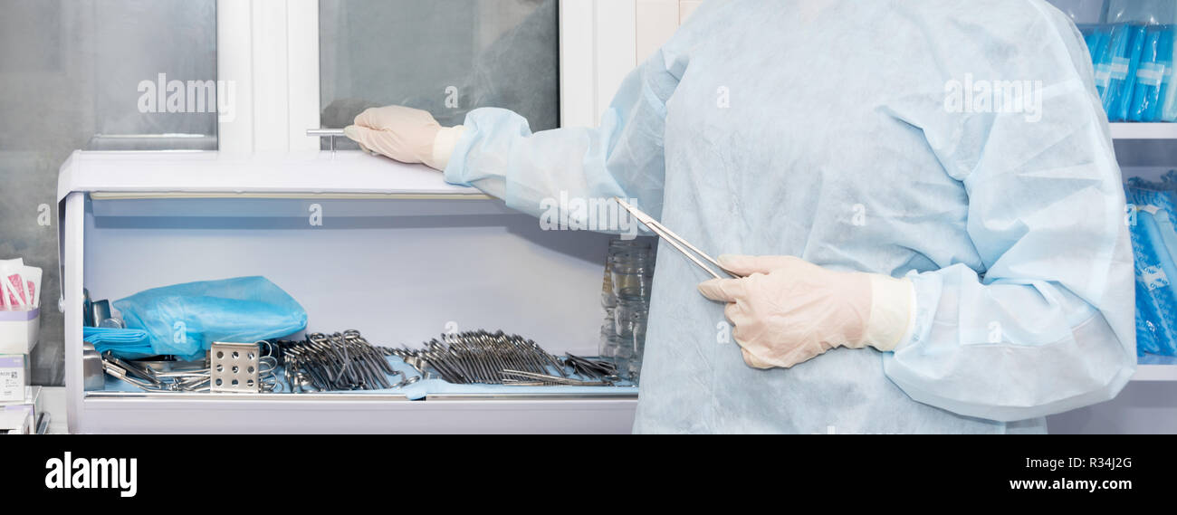Doctor's hand holding vascular clamps in the operating room