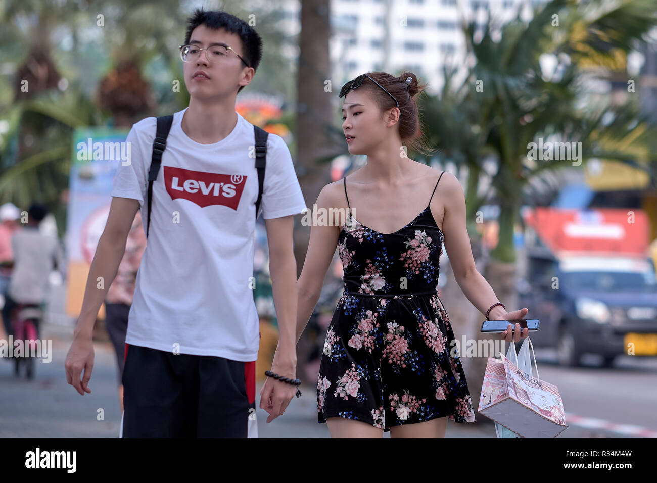 Young Asian couple walking hand in hand Stock Photo - Alamy