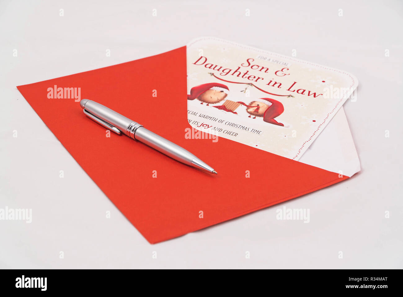 Christmas card for Son and Daughter in Law with red envelope and pen on white background Stock Photo