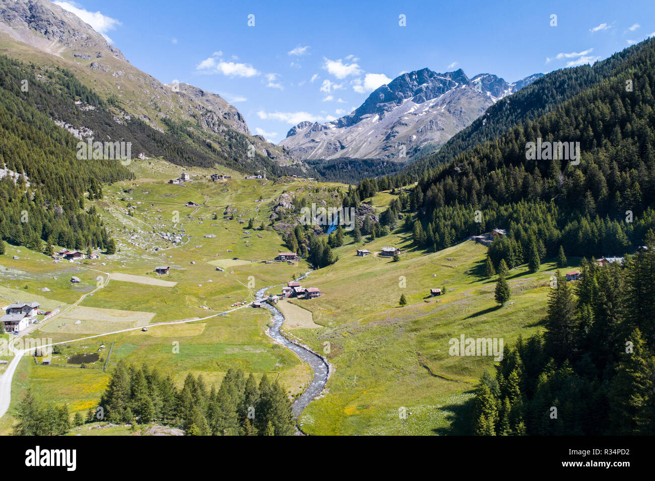 Val Grosina, Valtellina. Waterfall of Eita, green meadows and forest Stock Photo
