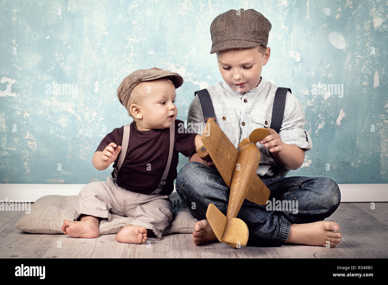 two brothers playing with wooden flyer Stock Photo