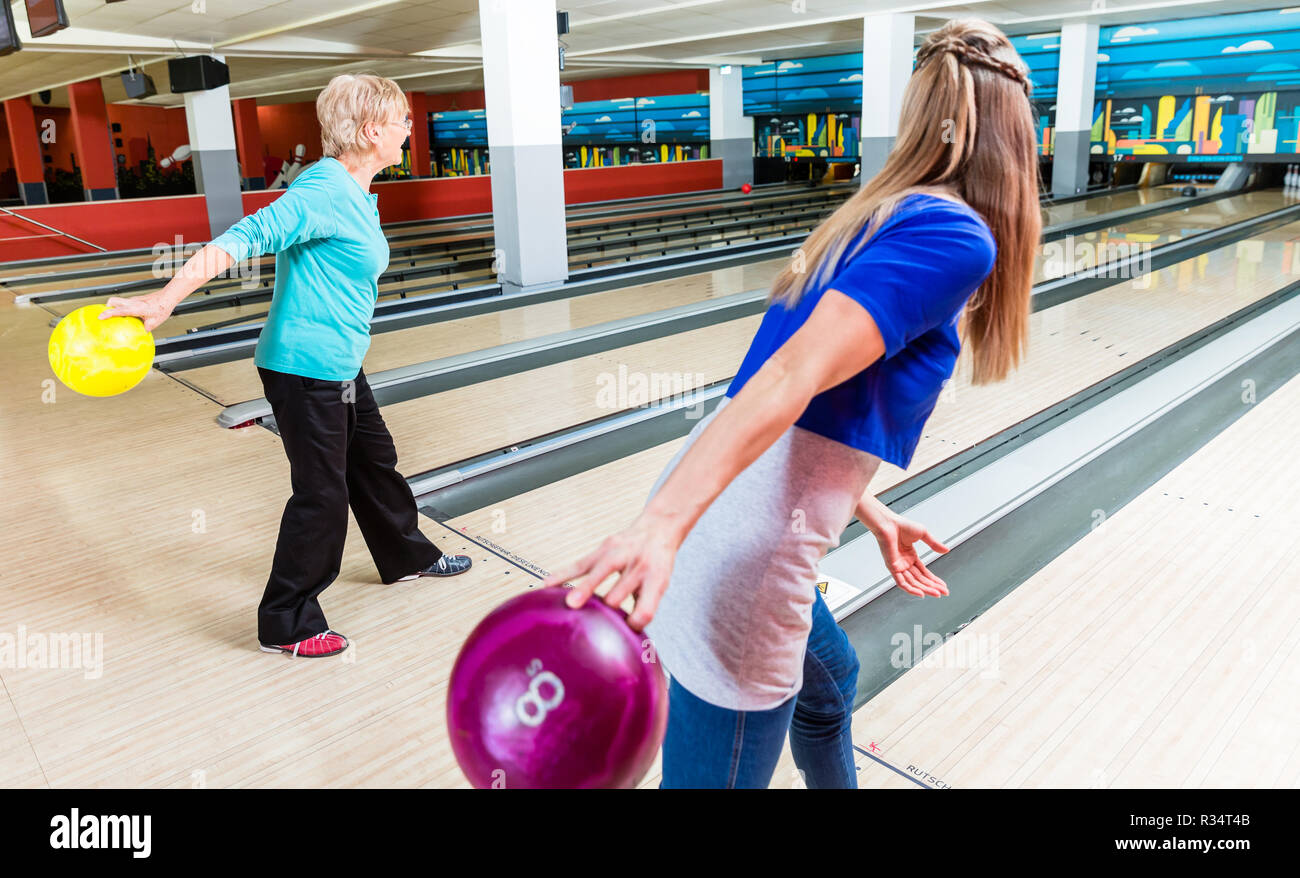 Mother and daughter playing bowling game Stock Photo