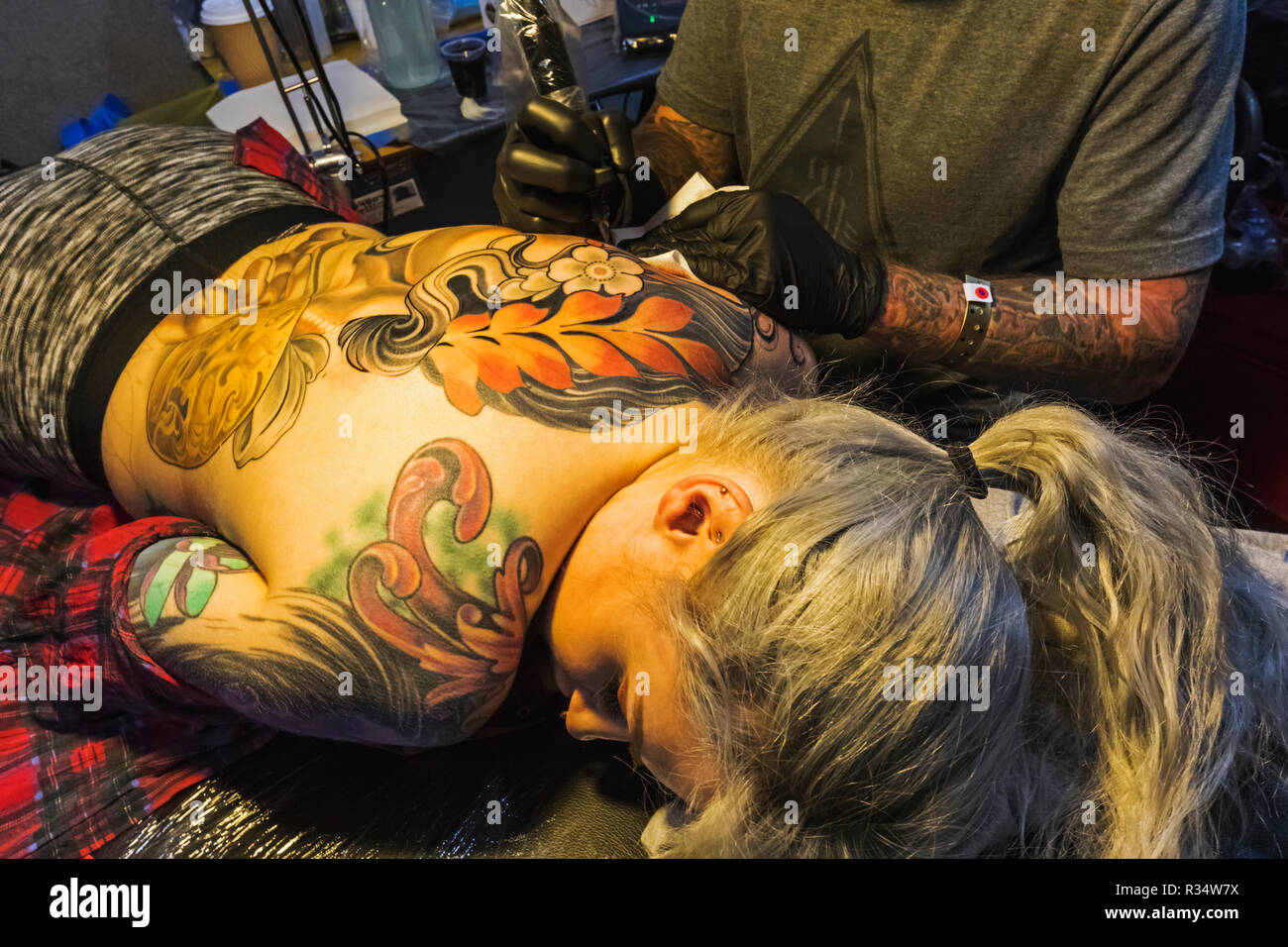 England, London, Wapping, Tobacco Dock, London Tattoo Convention, Woman Being Tattooed Stock Photo