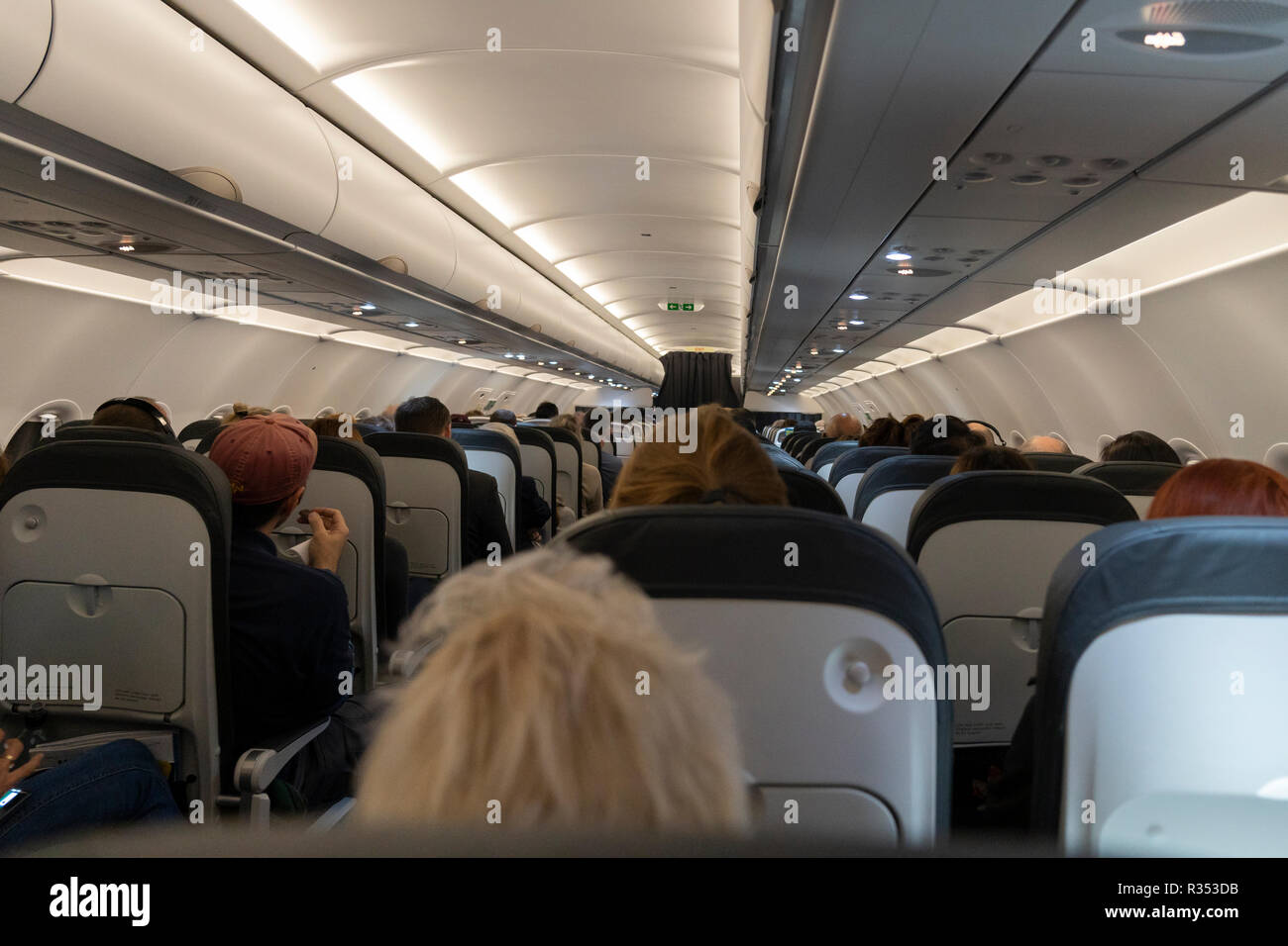 Seated passengers in the cabin of a passenger airliner on a British Airways evening flight Stock Photo