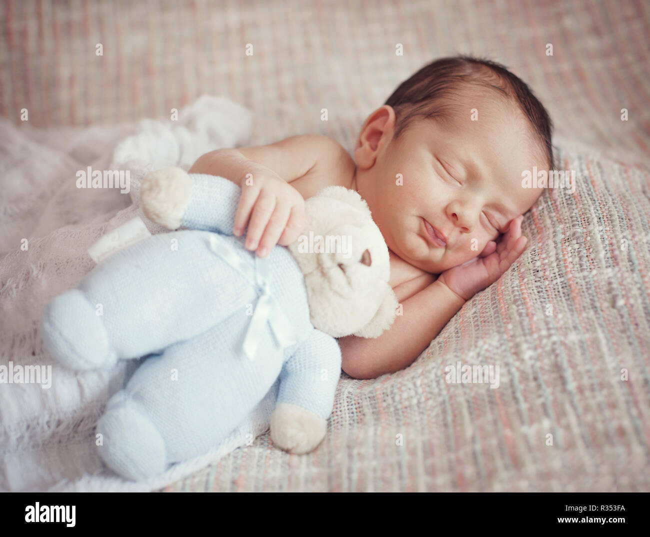 little baby is sleeping sweetly with a toy in his hands. Stock Photo