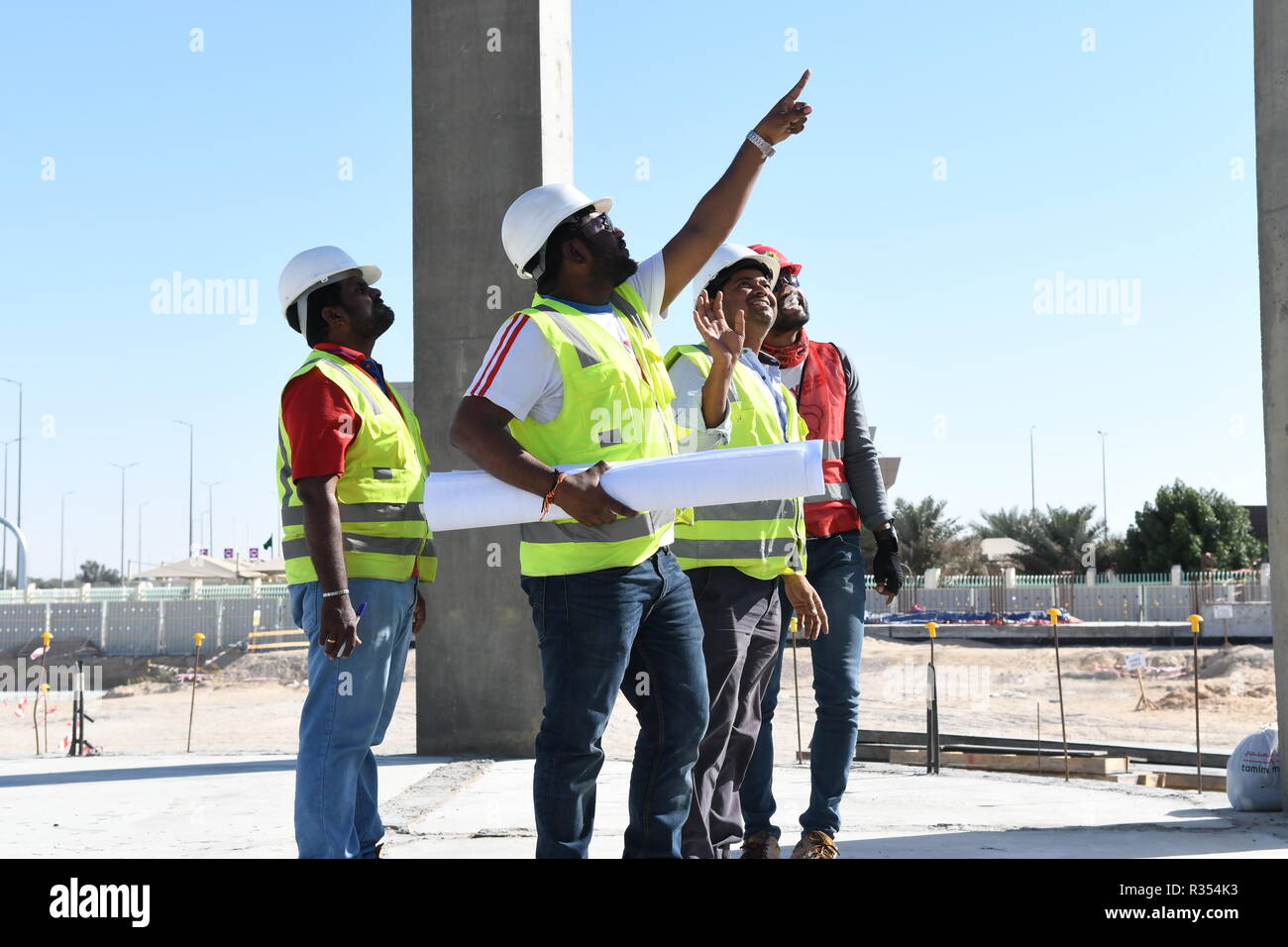 Men with Blueprints in hand are working in the construction Industry and  wearing hard hat and safety vest, they stay together under the blue sky and  s Stock Photo - Alamy
