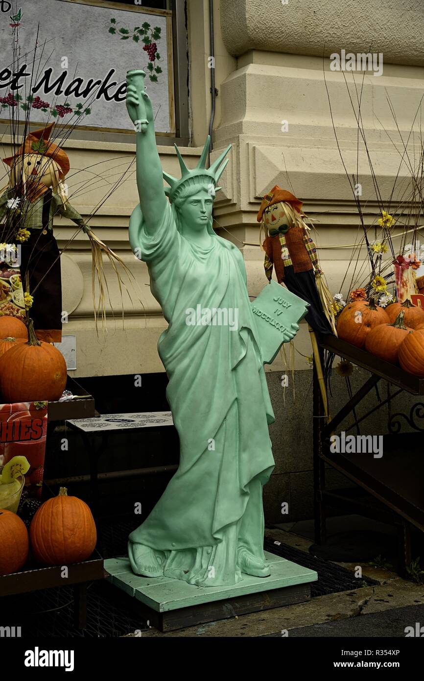 A smaller version of the Statue of Liberty surrounded by pumpkins and scarecrows Stock Photo