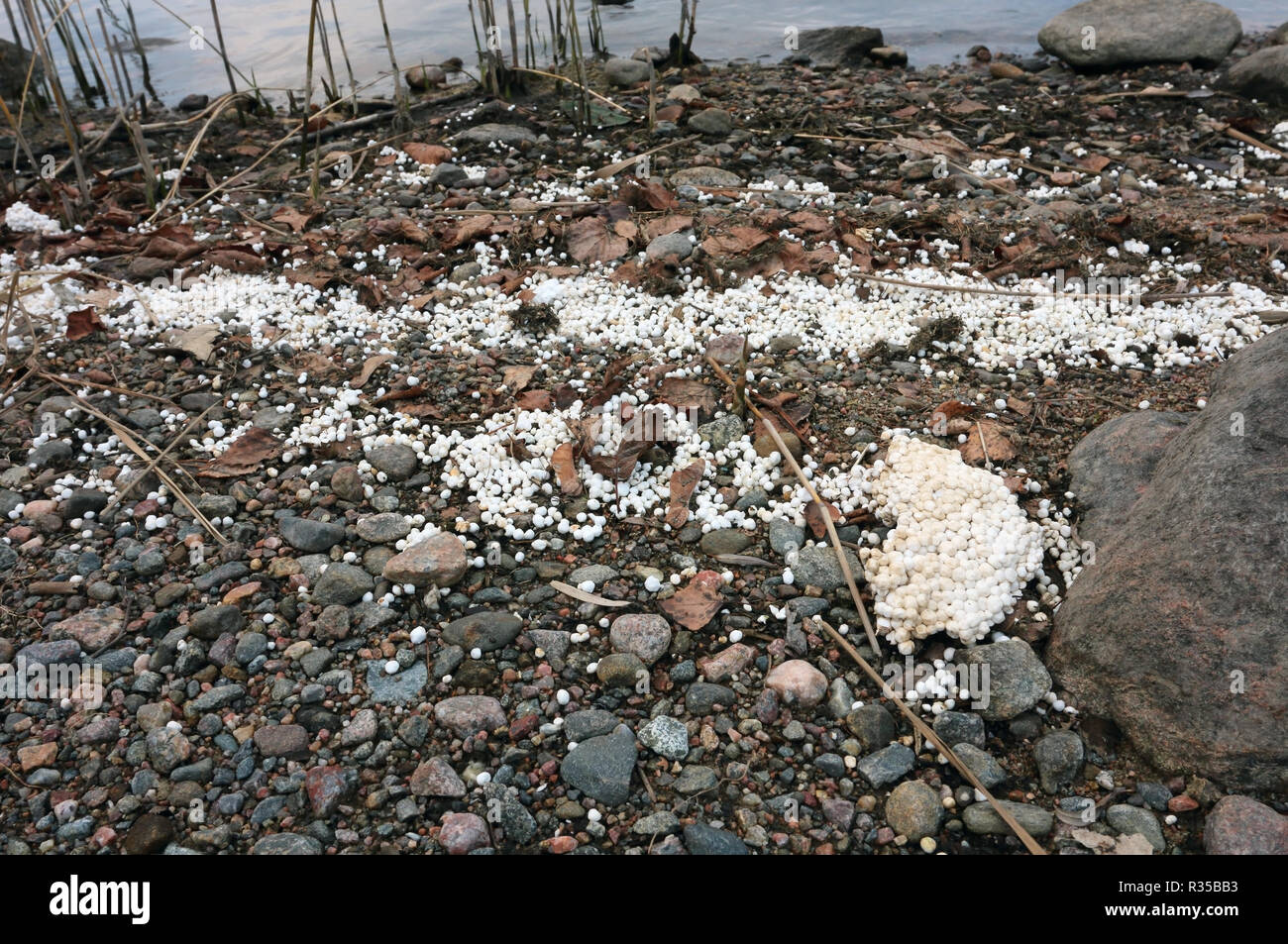 white styrofoam balls on lakeshore, Finland Stock Photo