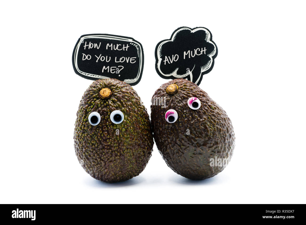 Romantic avocados couple with googly eyes and speech bubble as man and woman, funny food concept for creative projects. Stock Photo