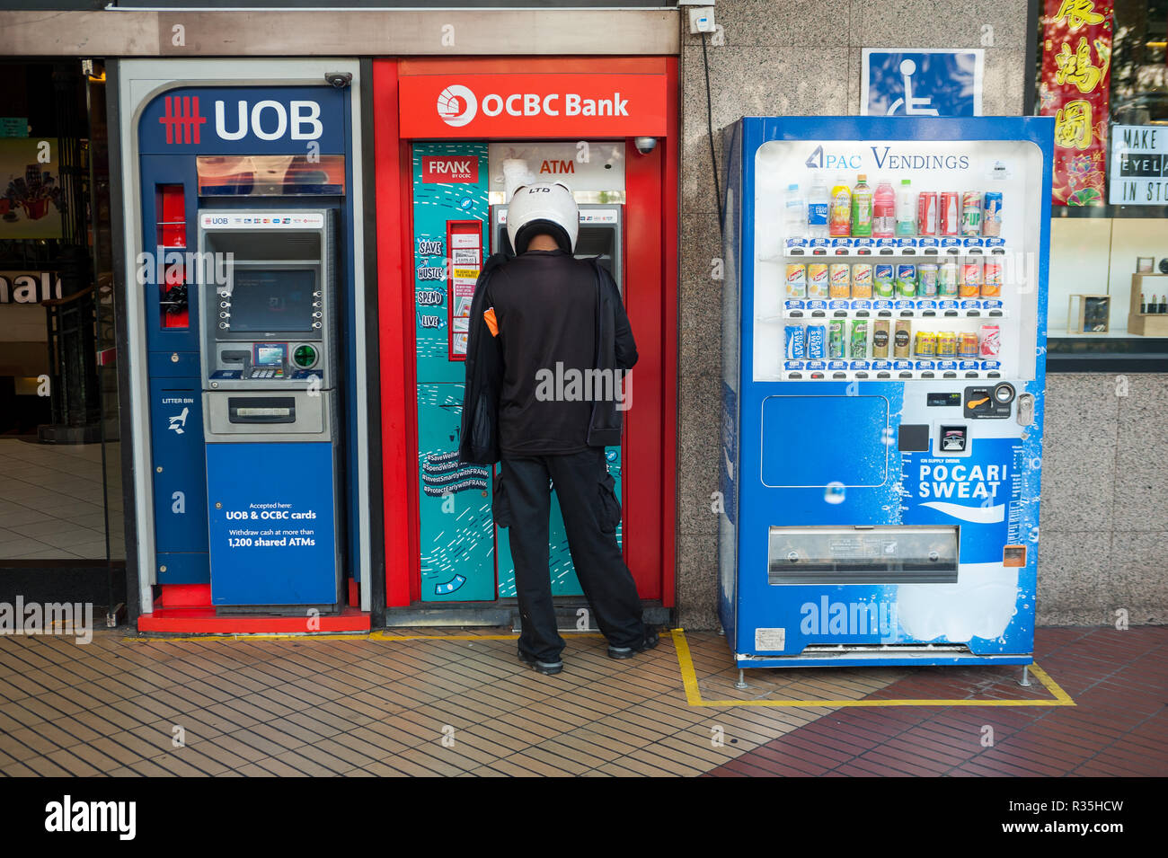 22.02.2018, Singapore, Republic of Singapore, Asia - A man is withdrawing money from a cash machine in downtown Singapore. Stock Photo