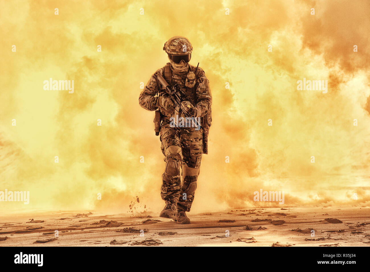 Army soldier in military camouflage uniform, helmet, with face hiding behind mask and glasses, running out from fire. Infantry rush with fire support, Stock Photo