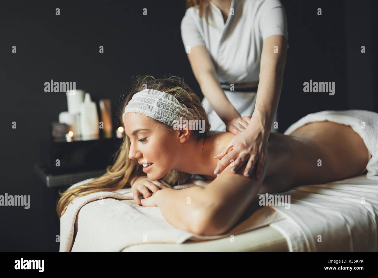Beautiful young and cute woman enjoying massage treatment Stock Photo