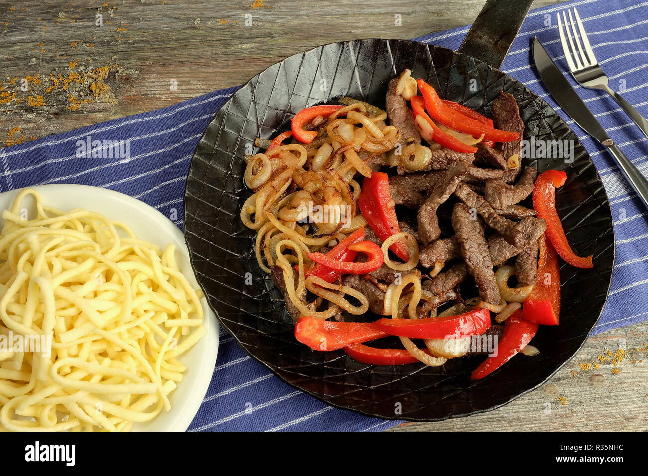 beef as sliced u200bu200bin a pan with onions and peppers Stock Photo