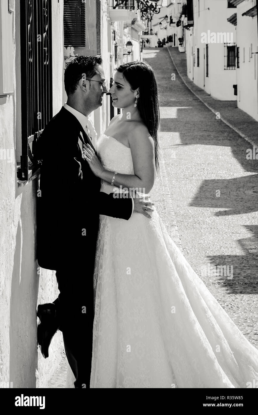 Bride and groom kissing in the street in a mediterranean village Stock ...