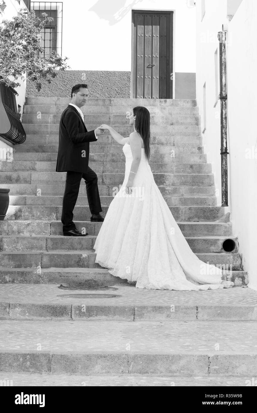 Young couple on their wedding day, on a large stairway Stock Photo