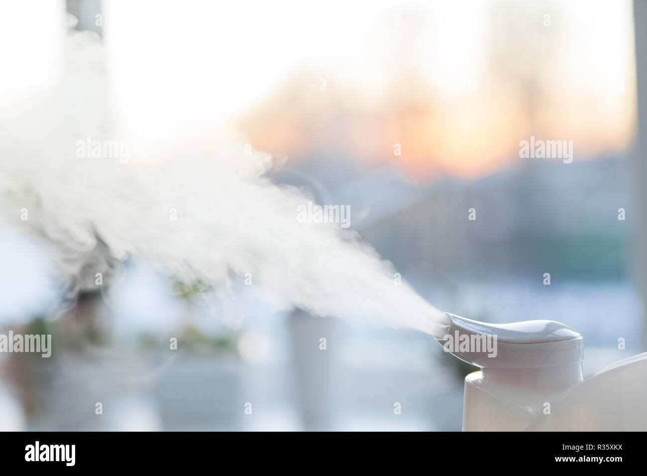 Humidifier on the window at sunset Stock Photo