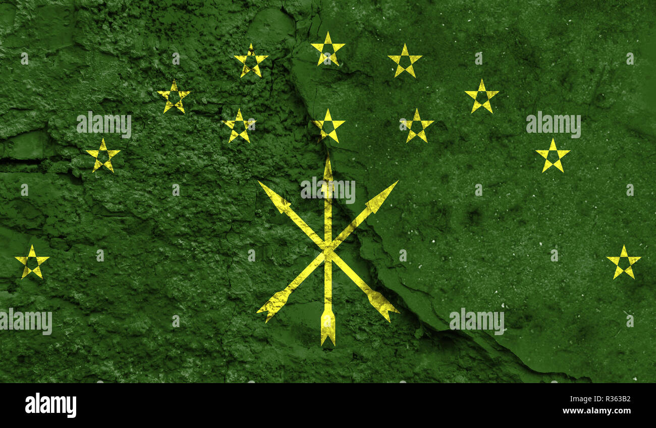 Flag of Adygea close up painted on a cracked wall, concept of armed actions and conflicts in the world Stock Photo