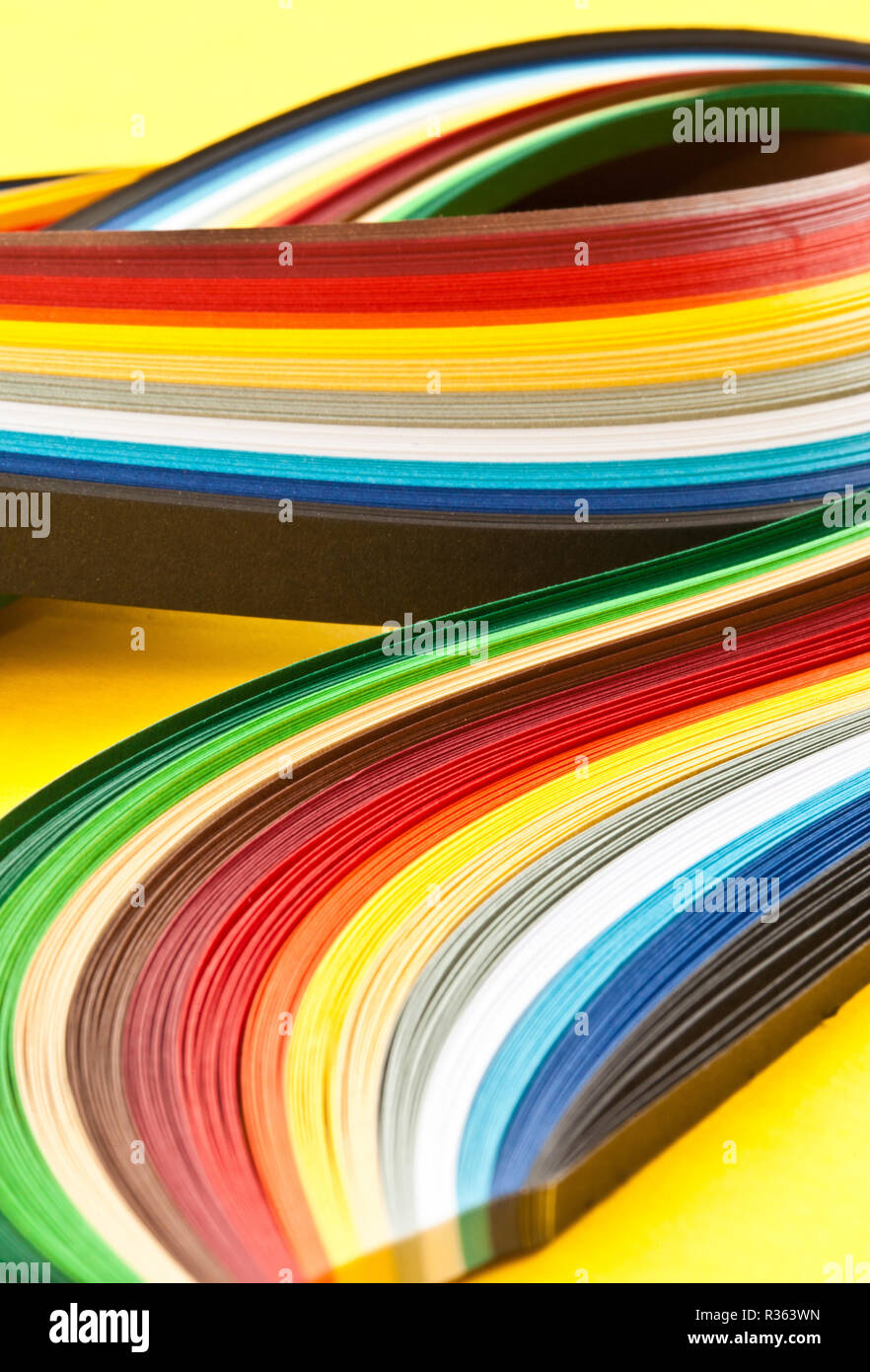 colorful paper strips on yellow Stock Photo