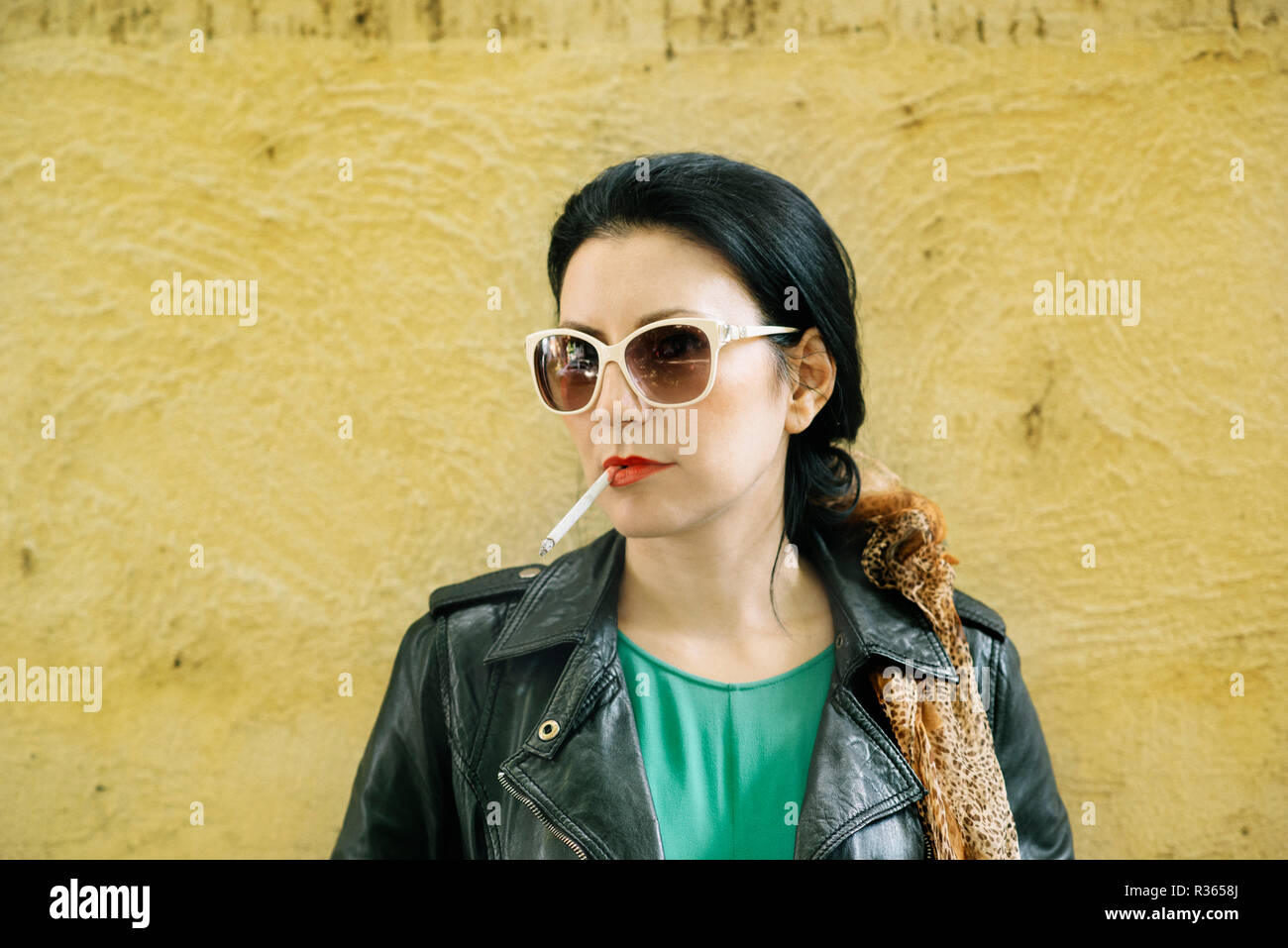 Modern young woman in fashion designer clothes smoking cigarette in