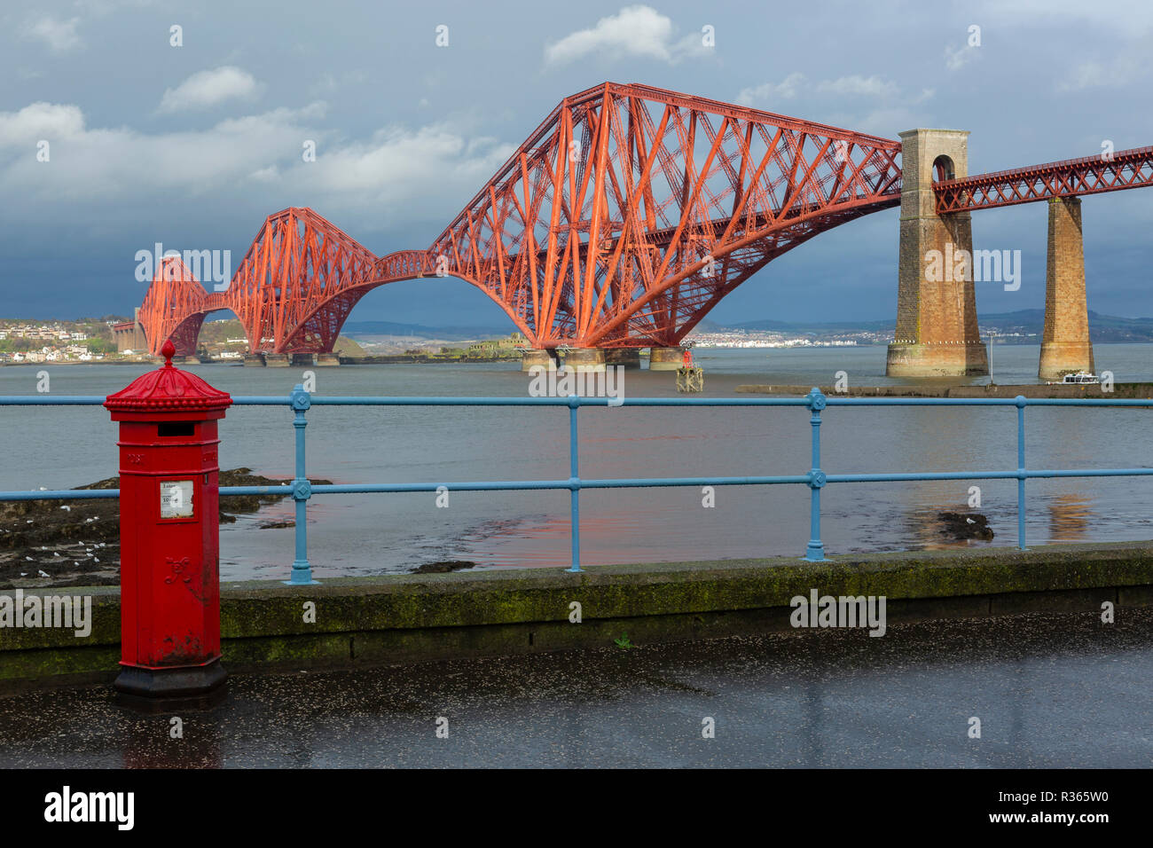 The Forth Rail Bridge from South Queensferry with Victorian red post box in foreground. South Queensferry, Edinburgh, Scotland Stock Photo