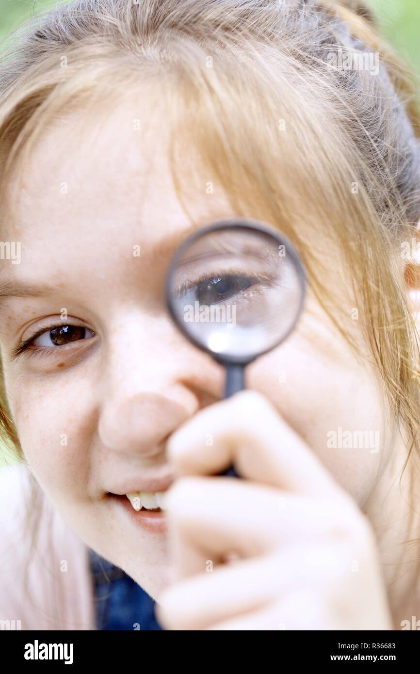 girl looking through a magnifying glass Stock Photo - Alamy