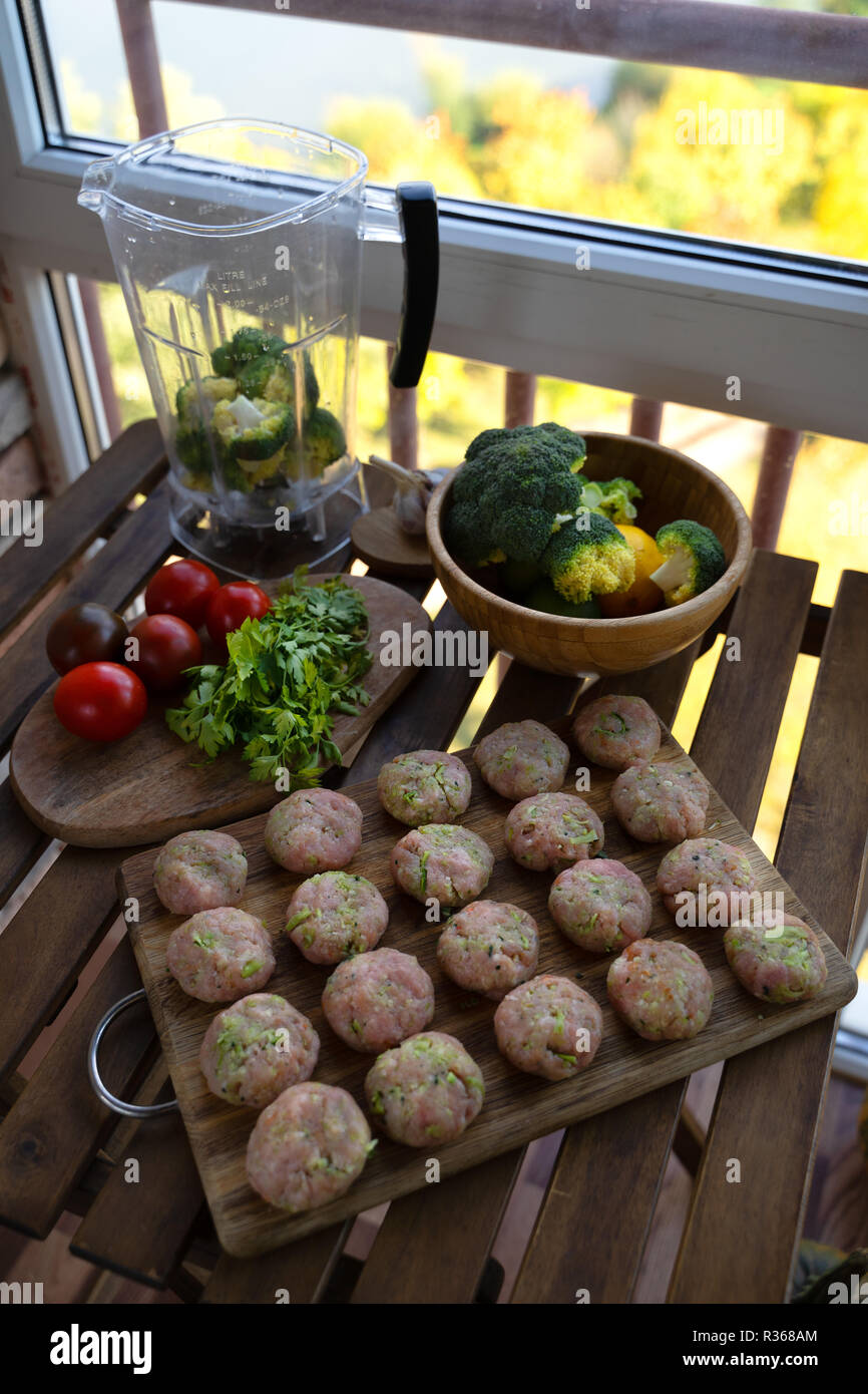 Homemade raw beef meatballs on a pan, before cooking, with vegetables Stock Photo