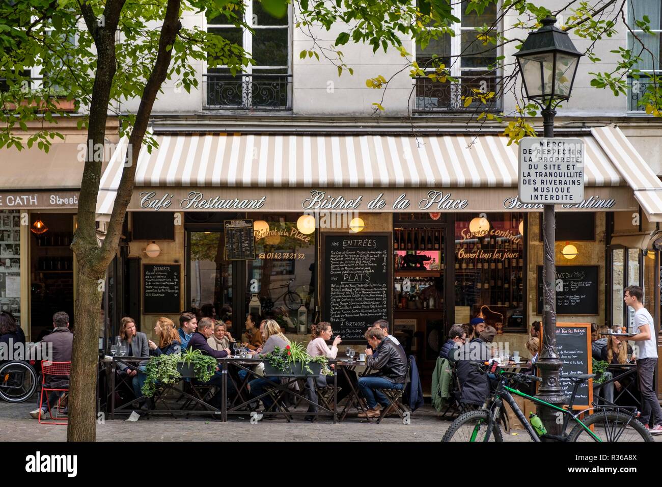 Busy outdoor cafe restaurant Au Bistrot De La Place, Place Sainte-Catherine, Marais, Paris, France Stock Photo