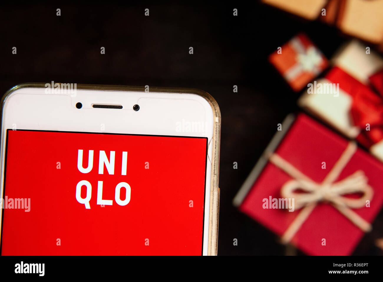 Japenese multinational clothing design retail company Uniqlo logo is seen  on an Android mobile device with a Christmas wrapped gifts in the  background Stock Photo - Alamy