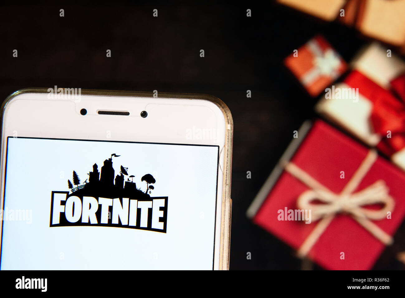 online video game by epic games company fortnite logo is seen on an android mobile device with a christmas wrapped gifts in the background - fortnite homepage android