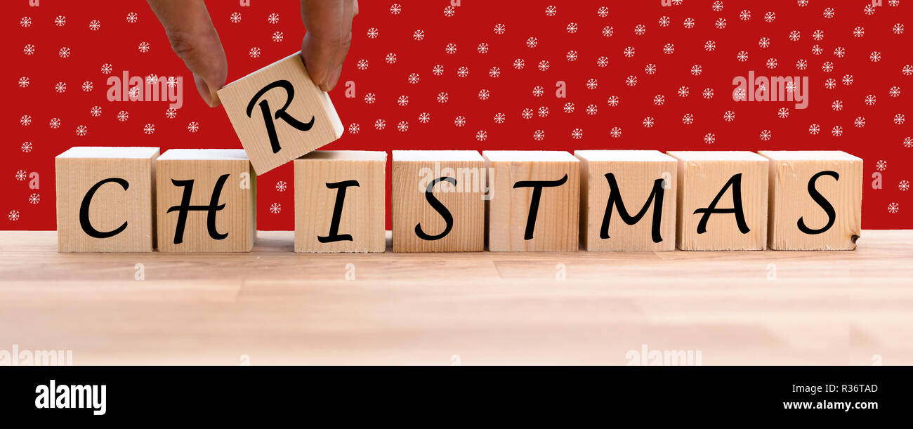 The word "CHRISTMAS" on dices infront of a red background Stock Photo