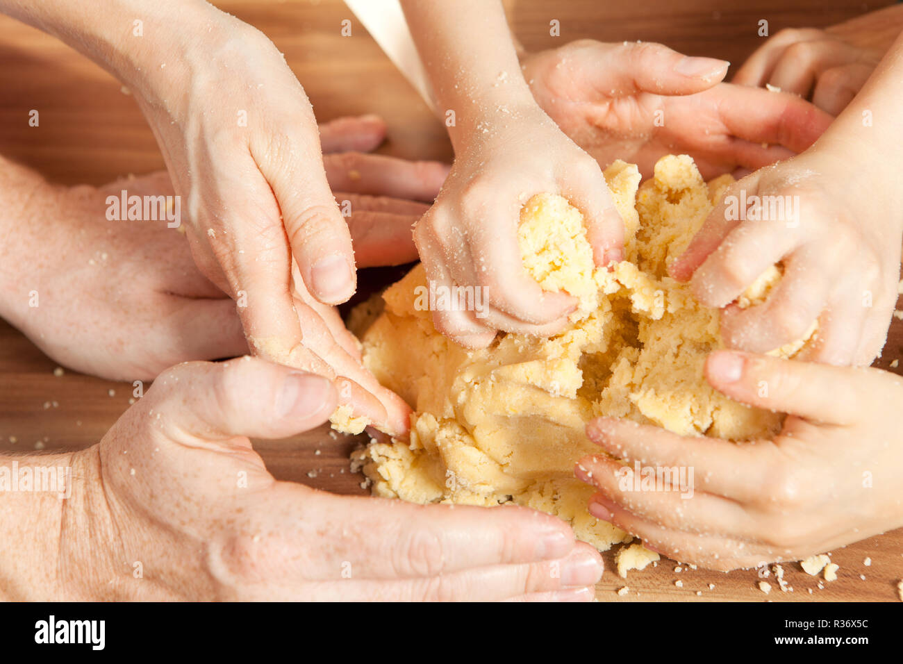 many hands knead the dough Stock Photo