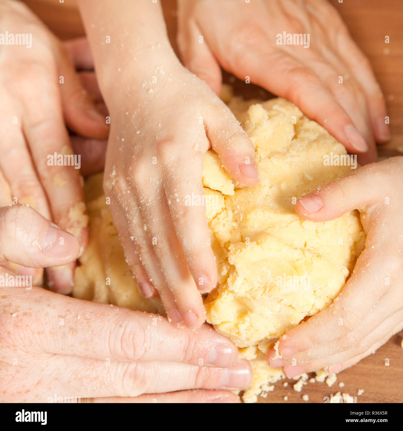 many hands knead the dough Stock Photo