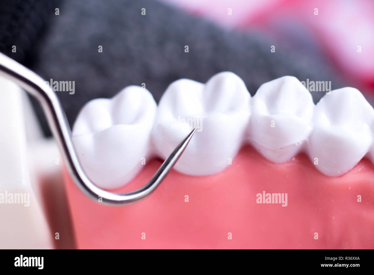 Dentist cleaning teeth with titanium metal tooth pick instrument to