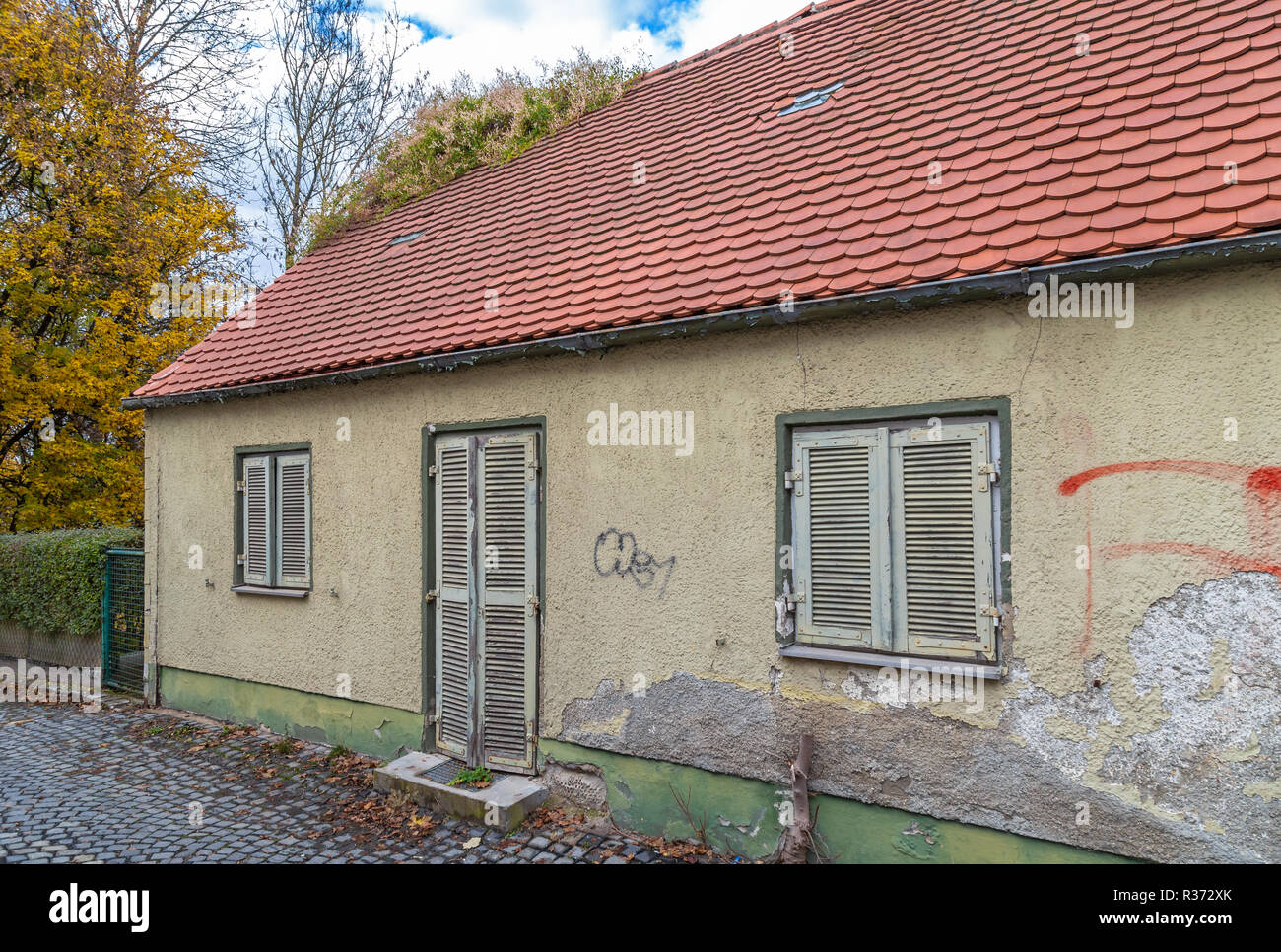 Old dilapidated house with grass on the roof Stock Photo