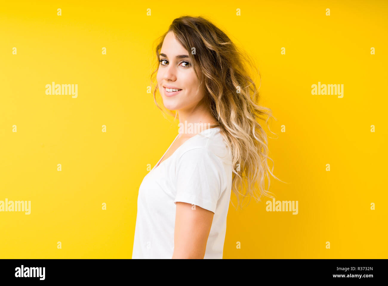 Young beautiful blonde woman over yellow background looking to side ...