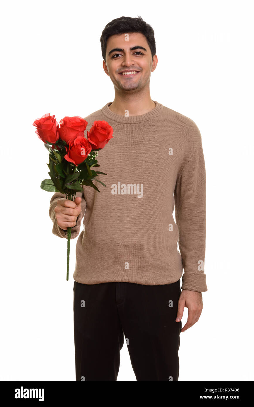 Young happy Persian man holding red roses ready for Valentine's Stock ...