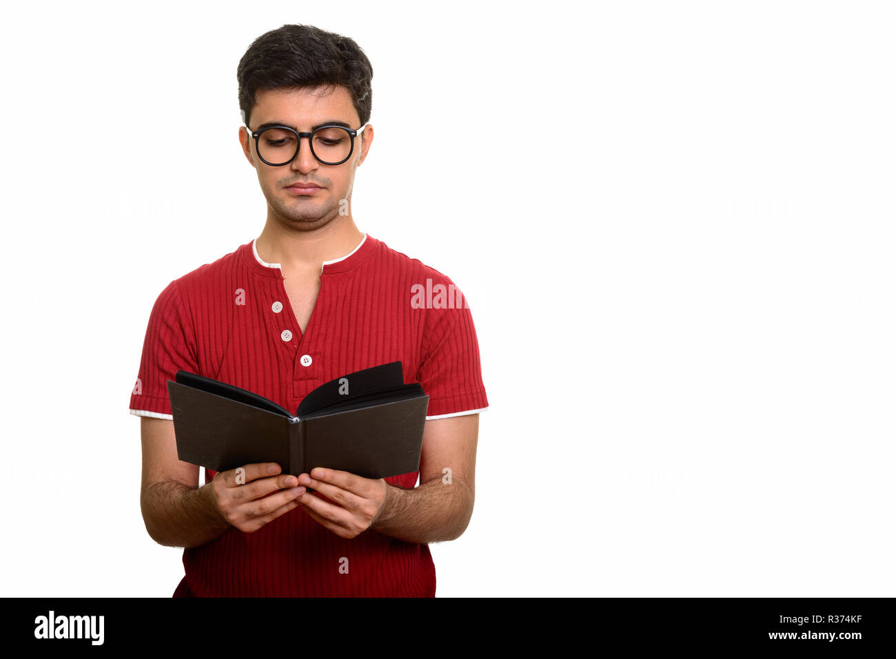 Young handsome Persian man reading book against white background Stock Photo