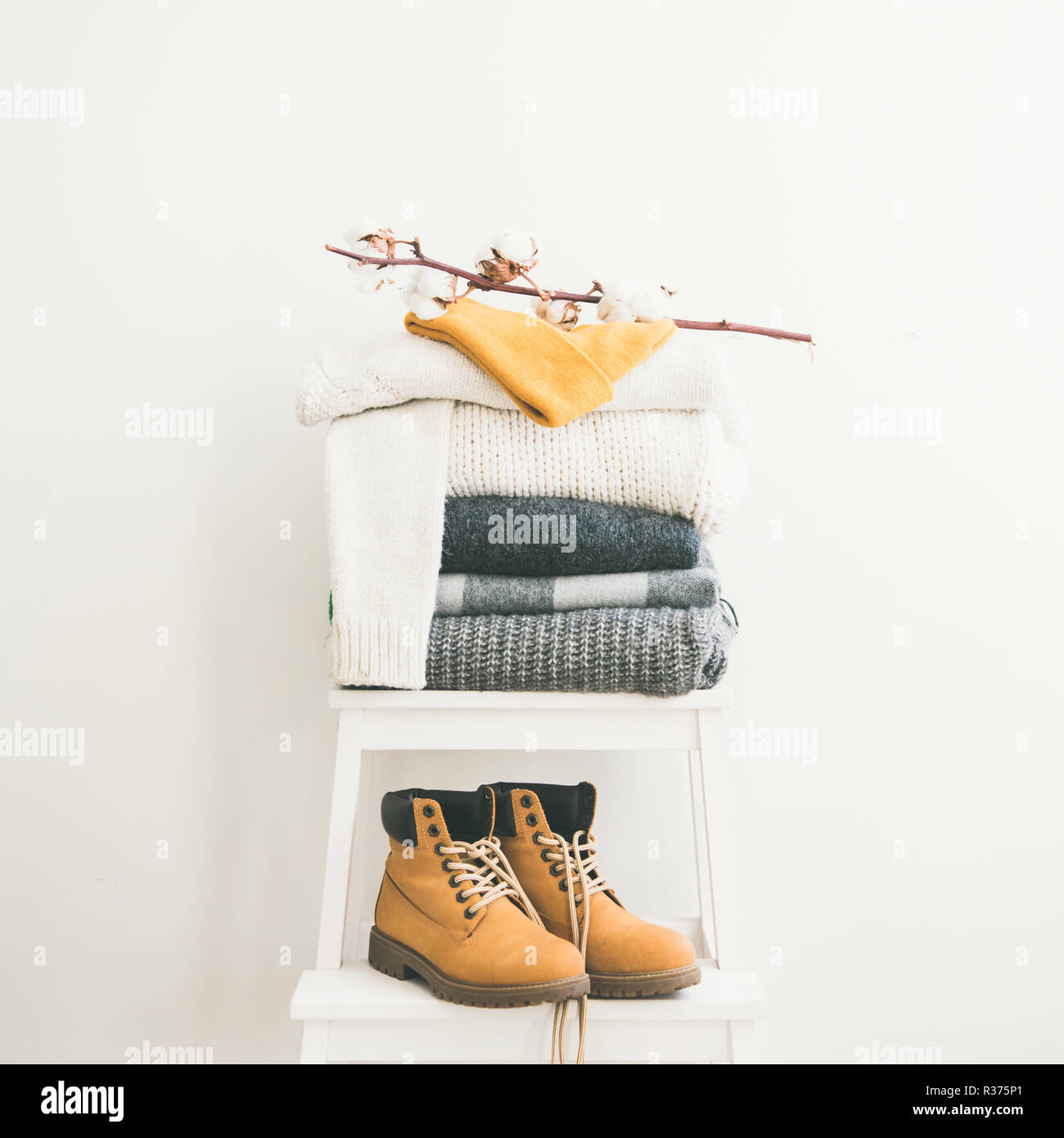 Warm clothing, blankets, boots and cap on chair, square crop Stock Photo