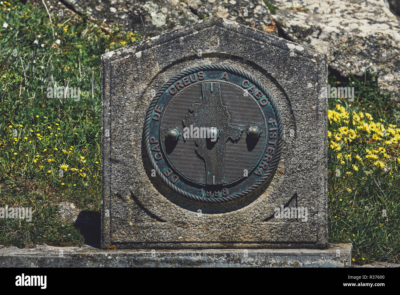 Informative signal with inscription on the cliff edge of Cape Finisterre - Fisterra - La Coruña, Galicia, Spain, Europe Stock Photo