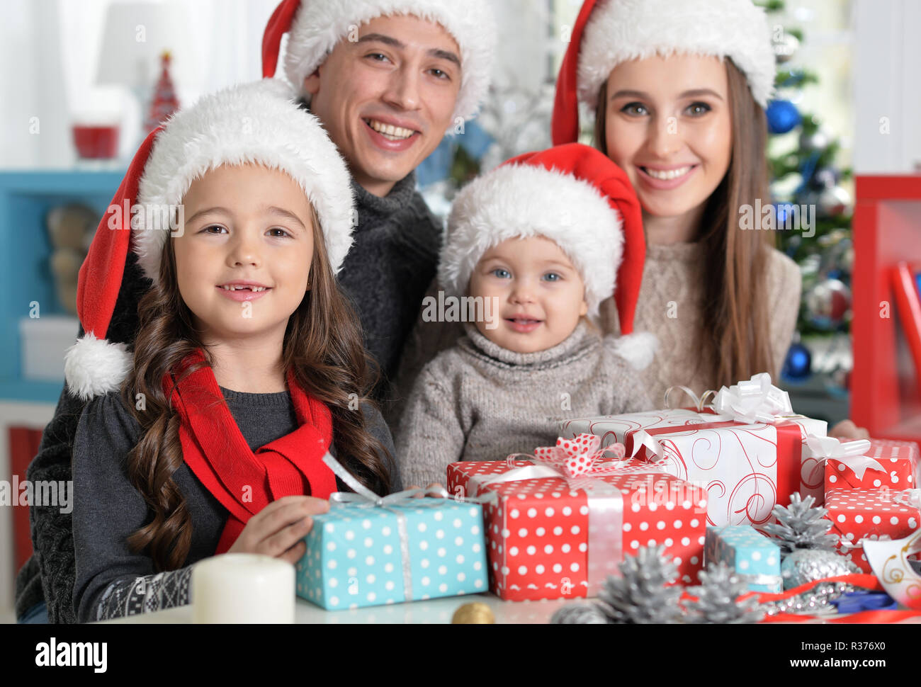 Happy family in Santa hats preparing for Christmas Stock Photo