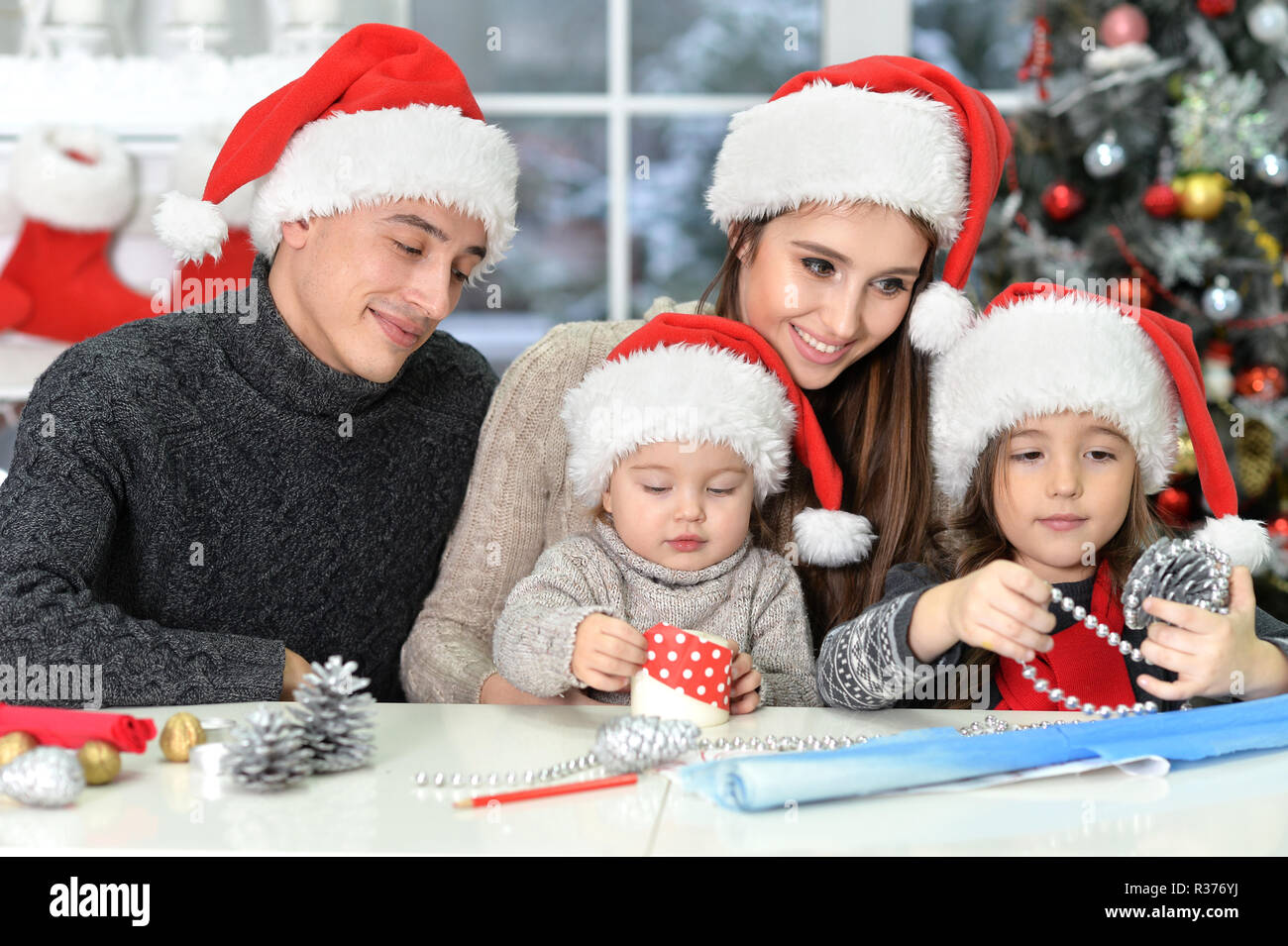 Happy family in Santa hats preparing for Christmas Stock Photo