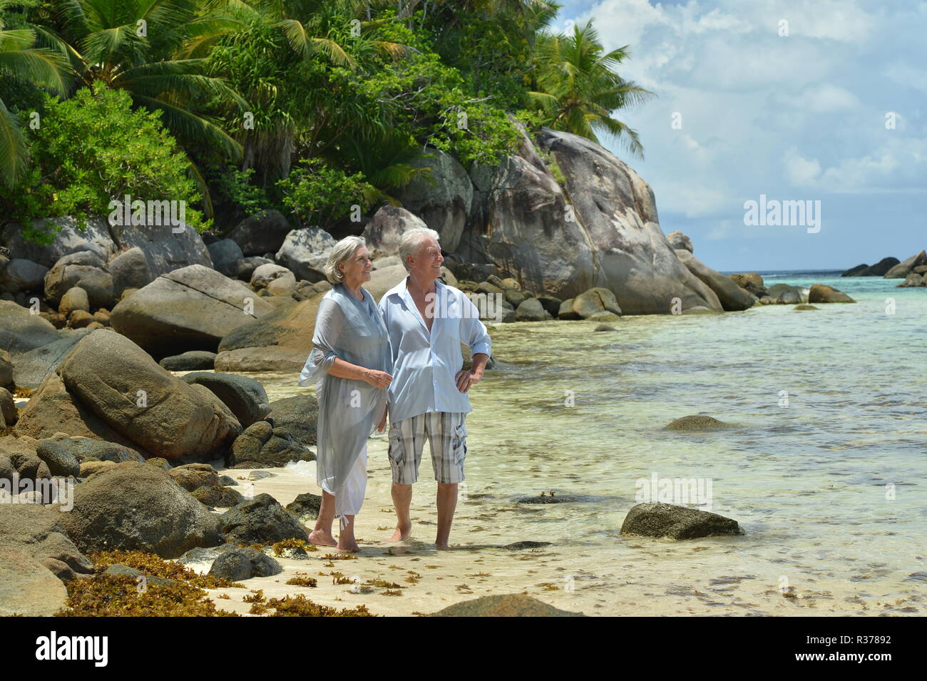 Portrait of happy elderly couple resting on tropical beach Stock Photo ...