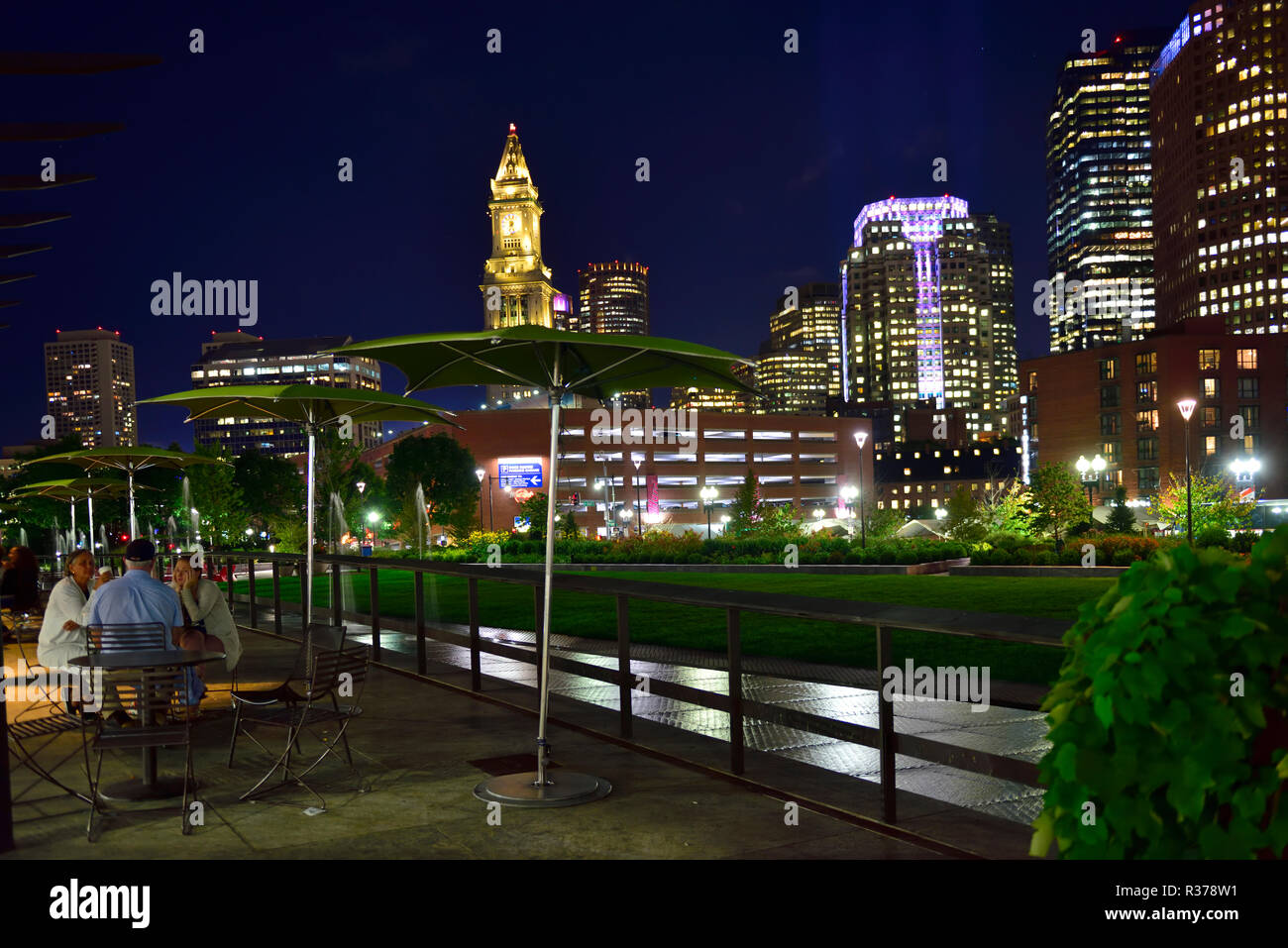 Night scene of open plaza and park with tall buildings of Boston financial district behind, Massachusetts, USA Stock Photo