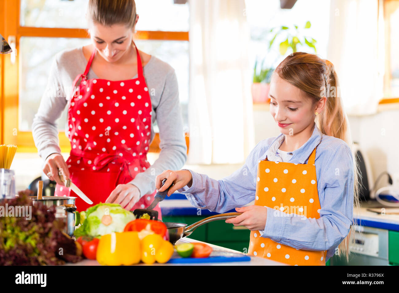 mother brings daughter cooking at Stock Photo